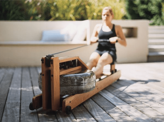 Working out with a water rowing machine on a deck
